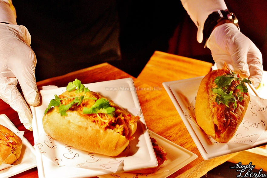 hands serving two sandwiches